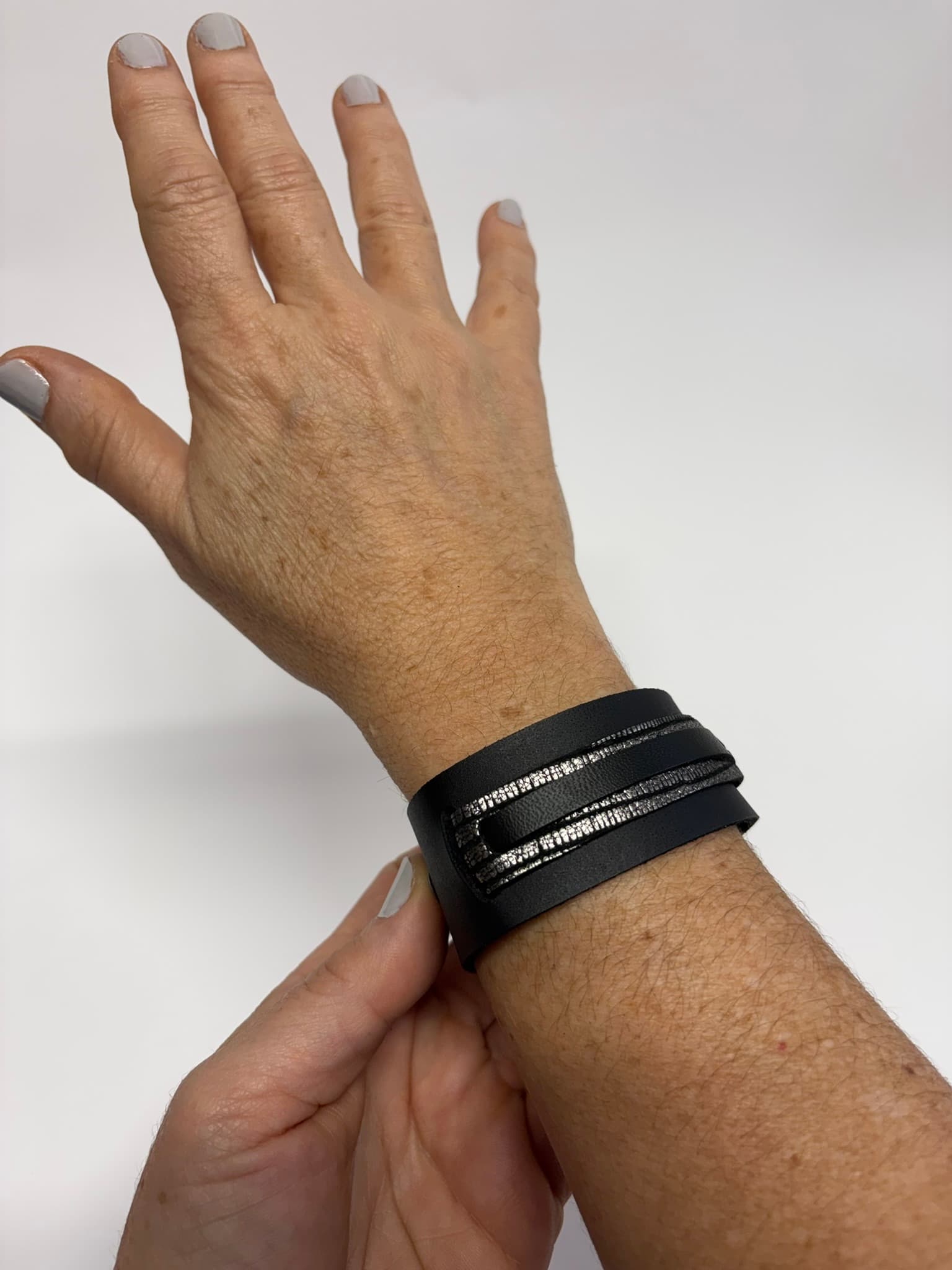 Detalle del brazalete de cuero negro y plateado – Courage Bracelet Mangel Delferri